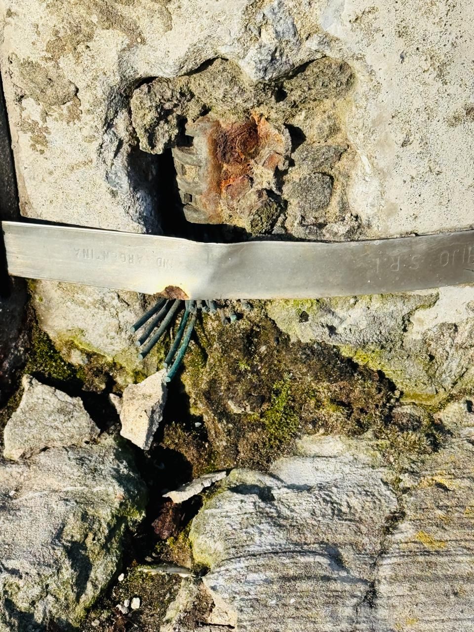 Detalle de base deteriorada con armadura expuesta y fisura